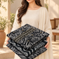 Woman holding the black and ivory embroidered Dhanak unstitched fabric set.